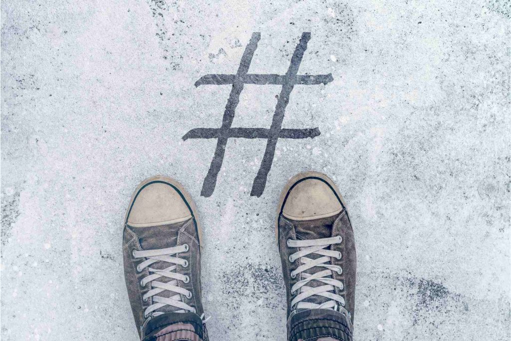 Stopala stoje iznad otiska hashtaga na ulici