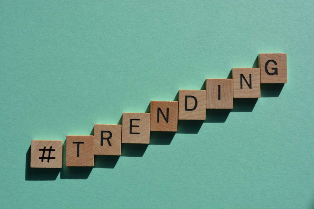 hashtagovana reč trending 3D drvenim slovima abecede na zeleno plavoj pozadini